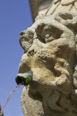 Pernes-Les-Fontaines Provence Fransa 'da mavi gökyüzüne karşı izole edilmiş bir çeşme taşının ayrıntıları