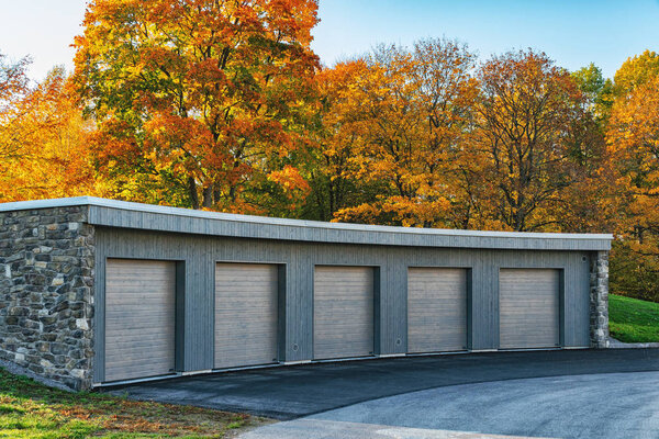 Набор повозок или гаражей подряд с деревьями и небом на заднем плане
.