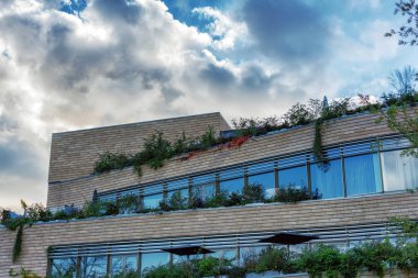 Cam pencere ve arka bulutlara ile dramatik mavi gökyüzü ile modern yapı.