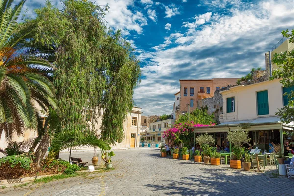 Chania, Greece - August, 2018: Picture of sunny street with people sitting in the cafe, with beautiful clouds — Stock Photo, Image