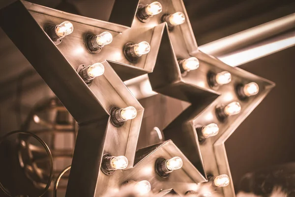 Grande estrela retro decorativa com muitas luzes acesas no fundo de concreto grunge. Bela decoração, elemento de design moderno . — Fotografia de Stock