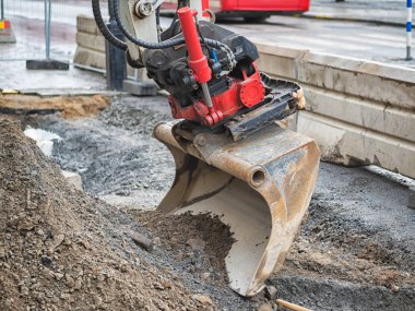 Arka planda ekskavatör, grader veya traktör kovası, şehir yolu yenileme yakın