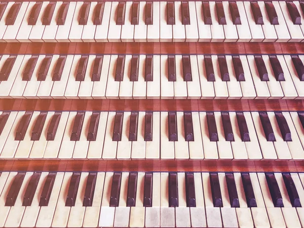 Close up view of a church pipe organ with four keyboards