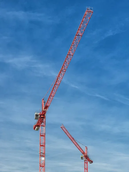 High-rise building, crane, blue sky, white clouds in the light of the setting sun — Stock Photo, Image