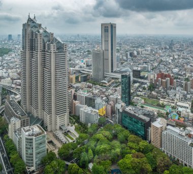 Gayrimenkul ve kurumsal inşaat için Asya iş konsepti - Tokyo, Japonya'da yağmurlu gökyüzü altında panoramik kentsel şehir silueti hava görünümü