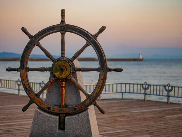 Καπετάνιος τιμόνι ή πηδάλιο ενός παλιού ξύλινο ιστιοπλοϊκό πλοίο σε ένα λιμάνι κατά το ηλιοβασίλεμα — Φωτογραφία Αρχείου