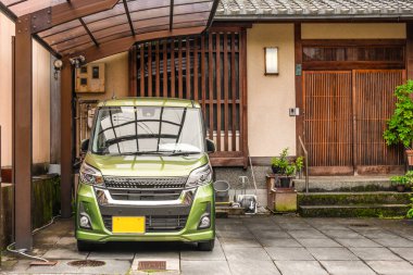 Japon stili ahşap eve giriş, Kei marka araba ile park edilmiş.