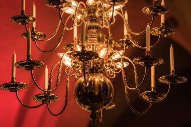 Altın kaplama avize simgeleri yanında eski kilise asılı. Mumlar gibi modern lambalar vardır.