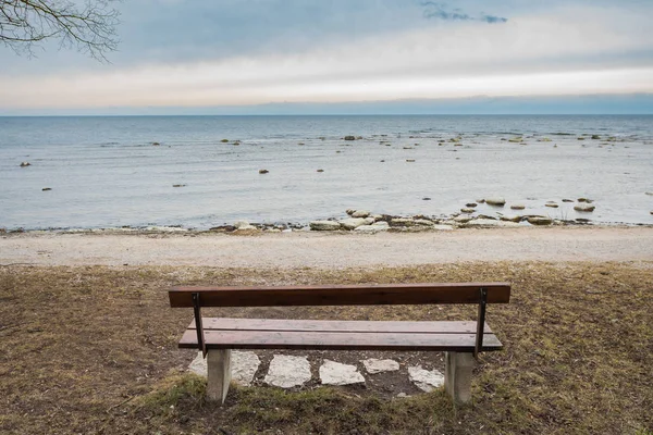 Banco de madera solitario en el mar de otoño con cielo nublado — Foto de Stock