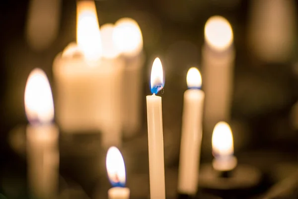 Mnoho hořících katolových žlutých svíček na speciálním stánku — Stock fotografie