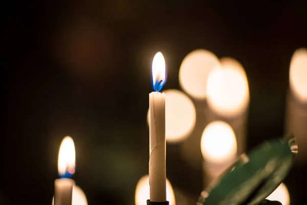 Mnoho hořících katolových žlutých svíček na speciálním stánku — Stock fotografie