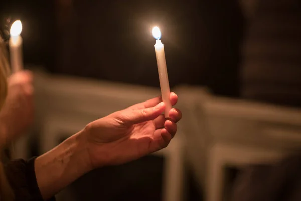 Pálení kostelních svíček v rukou dětí na tmavém pozadí — Stock fotografie