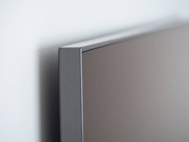 Boş modern düz ekran TV beyaz duvara sorunsuzca yapışık.