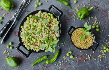 İsrail kuskus ptitim sebze ve gri arka plan üzerinde siyah yemeklerinde yeşil bezelye