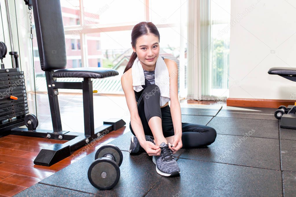 Young asian woman wearing running shoes at gym. Fitness and healthy concept
