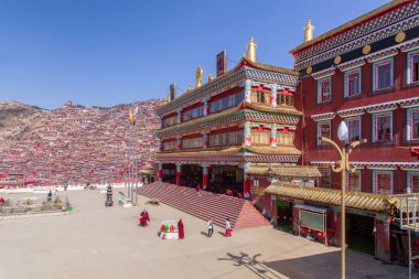 Kırmızı Manastırı ve güneşli gün ve arka plan Larung gar (Budist Akademisi) evde olduğunu mavi gökyüzü, Sichuan, Çin.