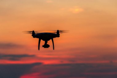 Gün batımında okyanus üzerinde uçan drone