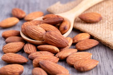 Masadaki tahta kaşıkta badem. Kopyalama alanı ile badem kavramı. 