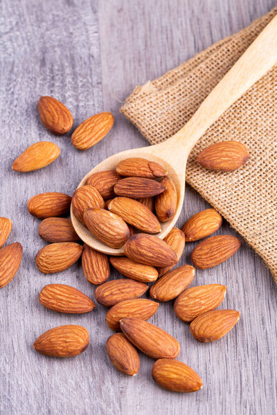 Almonds in a wooden spoon on the table. Almond concept with copy space. 