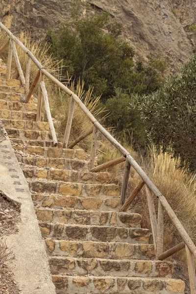 foreground of stone stairs with a wooden railing in the mountain
