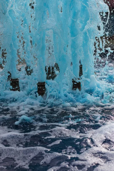 Primer plano en vista vertical de una fuente que expulsa agua azul — Foto de Stock