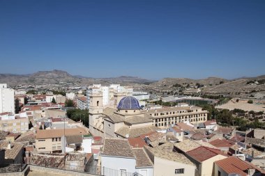 picture taken from the castle of the municipality of petrer in the province of alicante, spain with houses, church of san bartolome and mountains in the background. clipart