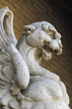 arka plan olarak tuğla bir duvar ile taşa oyulmuş gargoyle