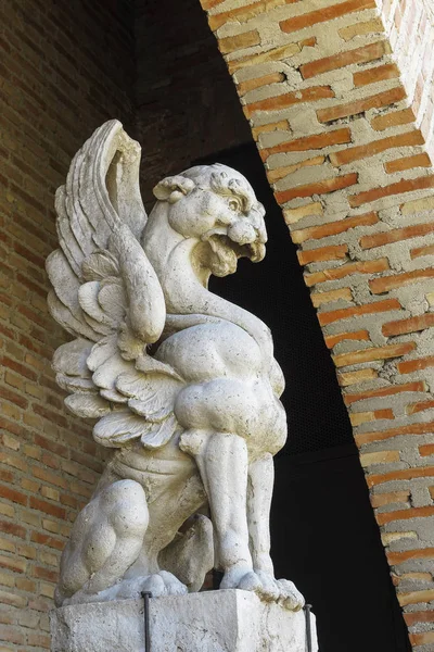 arka plan olarak tuğla bir duvar ile taşa oyulmuş bir gargoyle yan görünümü