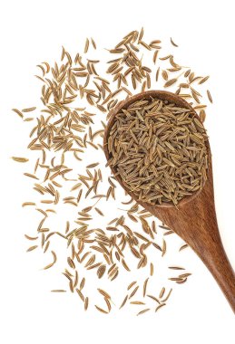 Tahta kaşık beyaz arka plan üzerinde izole içinde kurutulmuş kimyon tohumu. Üstten görünüm.