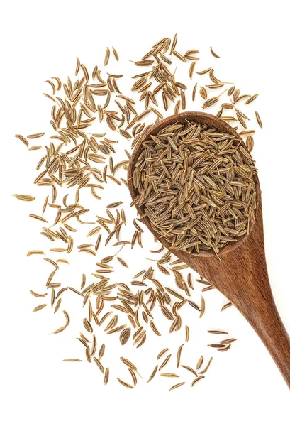 Tahta kaşık beyaz arka plan üzerinde izole içinde kurutulmuş kimyon tohumu. Üstten görünüm.