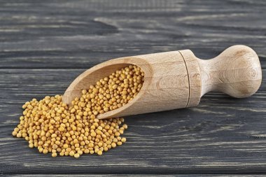 Ahşap kepçe, baharatlı hardal tohumu ahşap arka plan