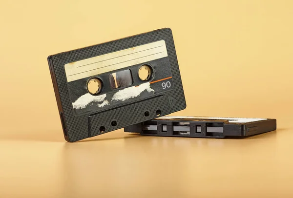 Two vintage audio cassette on brown background