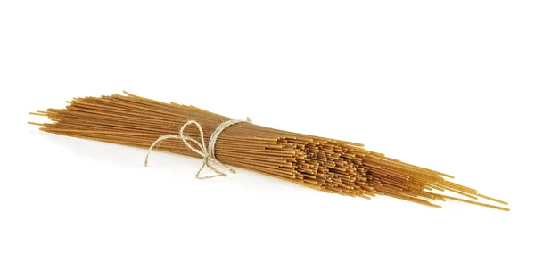 Fechar de uma pilha de espaguete de trigo integral cru, fundo branco — Fotografia de Stock
