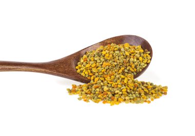 Beyaz bir arka plan üzerinde tahta kaşıkta arı poleni