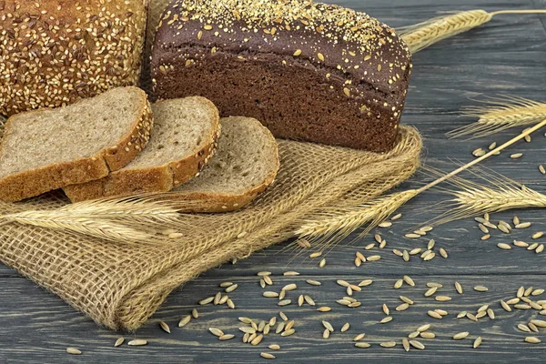 Roggenbrot und Roggen auf Holztisch — Stockfoto