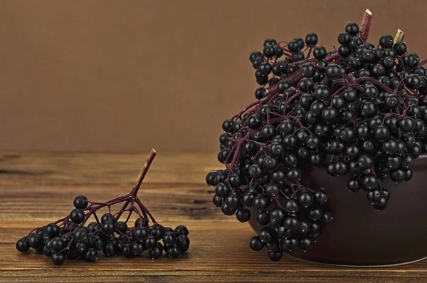 Elderberry in a ceramic bowl, on wooden desk. Healing berries of — Stock Photo, Image