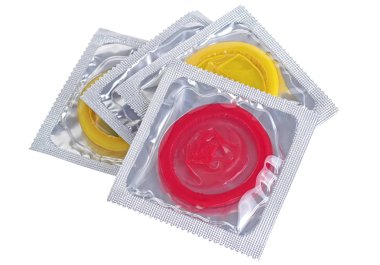 Beyaz bir arka plan üzerinde izole üç renkli prezervatif paketi