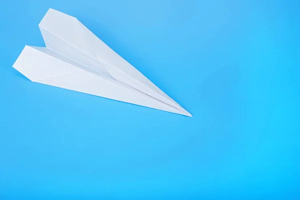 White paper airplane on a blue background. Travel plane concept.
