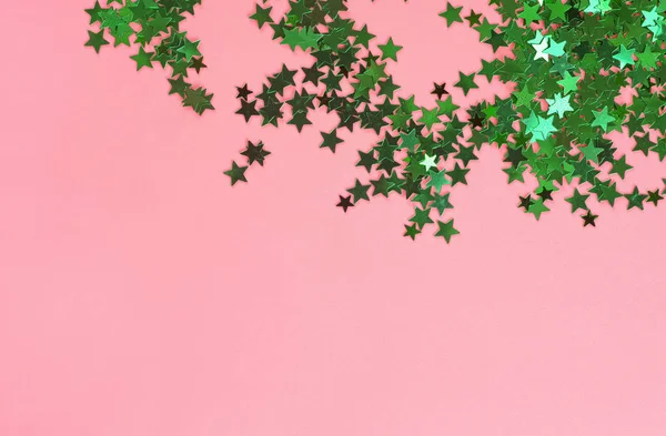 Zielone błyszczące gwiazdki na różowym tle. Świąteczny urlop pastelowy b — Zdjęcie stockowe