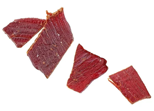 Beef jerky bitar på en vit bakgrund, ovanifrån. — Stockfoto