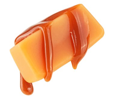 Karamel sosu beyaz arka planda izole edilmiş karamel şekerlere akıyor. Uçan karamel şekeri. Uçan karamel şekerler.