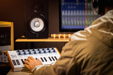 producer hands playing midi keyboard for recording in home studio, music production concept clipart