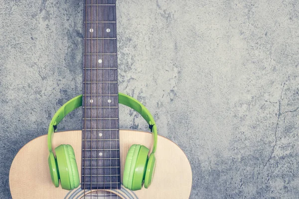 绿色耳机在声学吉他 音乐背景 — 图库照片