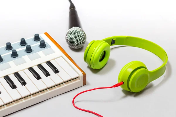 green headphone, microphone and keyboard, music concept
