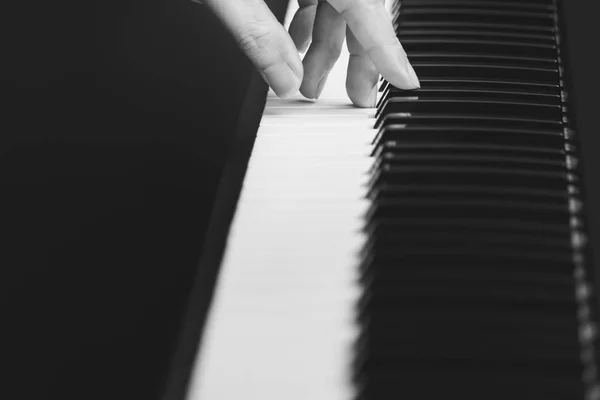 musician fingers playing on piano keys, black and white. music background