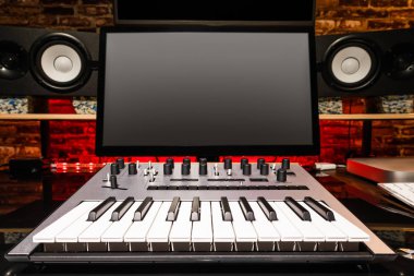ev stüdyosu. kayıt donanımları, bilgisayar monitörü, MIDI klavye, analog synthesizer, stüdyo hoparlörler monitör
