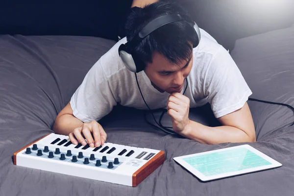 Asiatischer Männlicher Musiker Komponiert Nachts Ein Lied Auf Dem Bett — Stockfoto