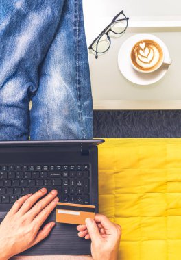 oturma odasında online alışveriş için kredi kartı tutan adam üst görünümü. e-ticaret konsepti
