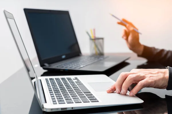 male graphic designer working on laptop computer with color pencils