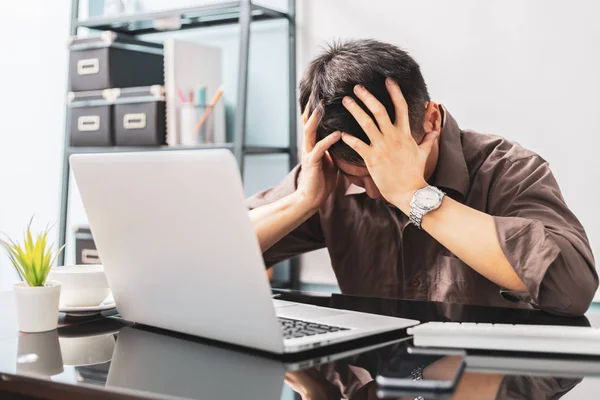 オフィスでストレスの多い一日を机の上に座りながら手をつないでいる若いアジア人ビジネスマン — ストック写真